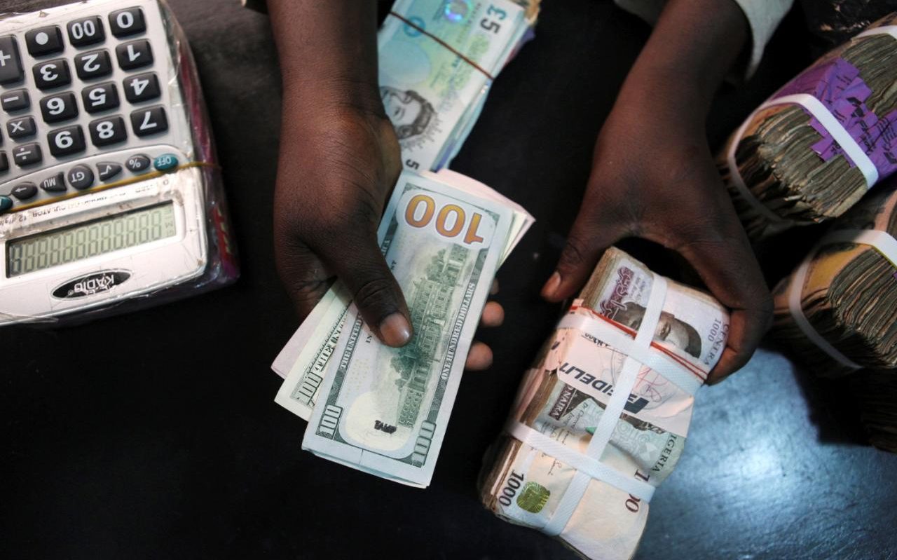101175644_A_trader_changes_dollars_for_naira_at_a_currency_exchange_store_in_Lagos_Nigeria_Febru-xlarge_trans++eo_i_u9APj8RuoebjoAHt0k9u7HhRJvuo-ZLenGRumA