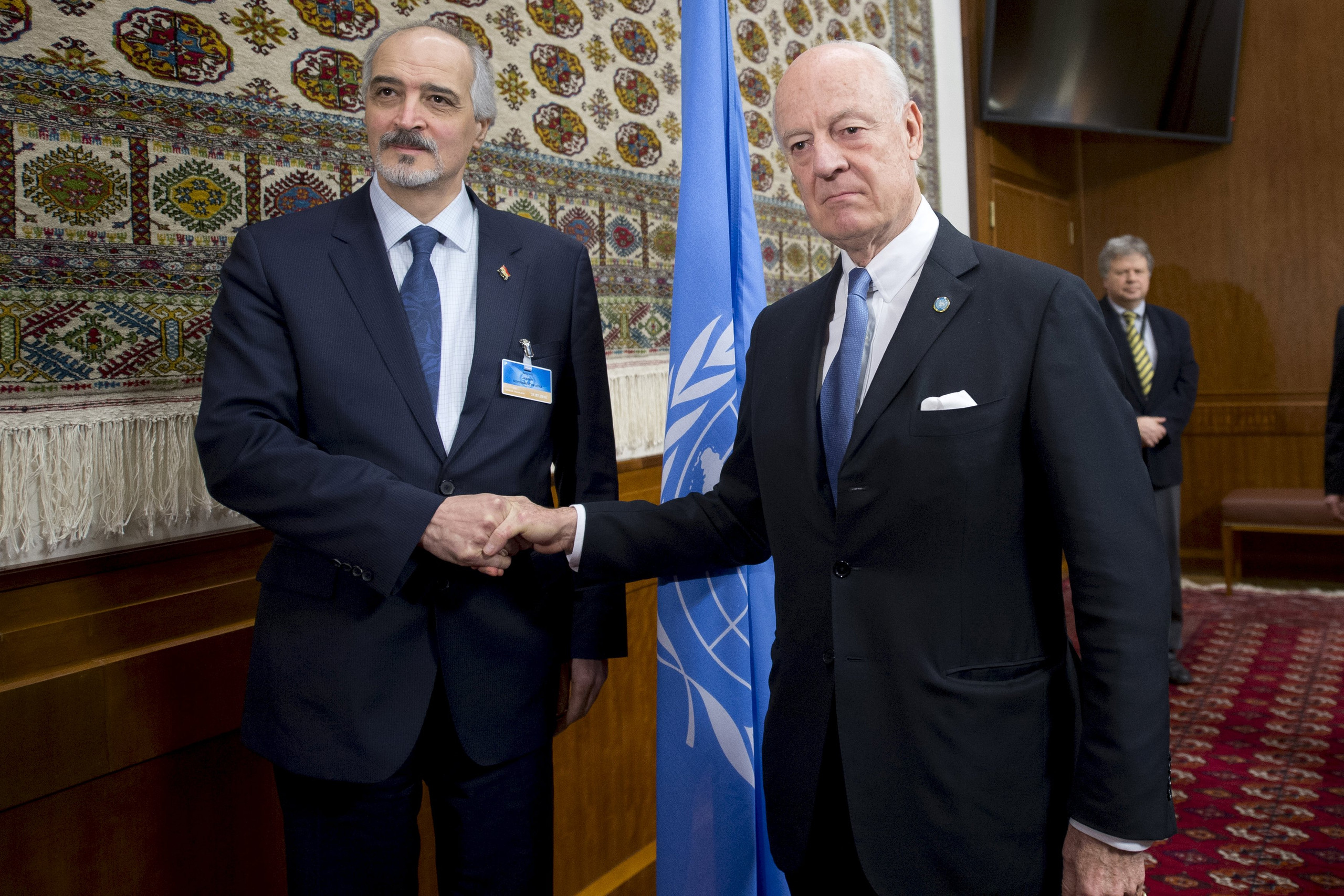 U.N. envoy Staffan de Mistura shakes hands with Syria’s Ambassador to UN Bashar al Jaafari during the Syria peace talks in Geneva, Switzerland