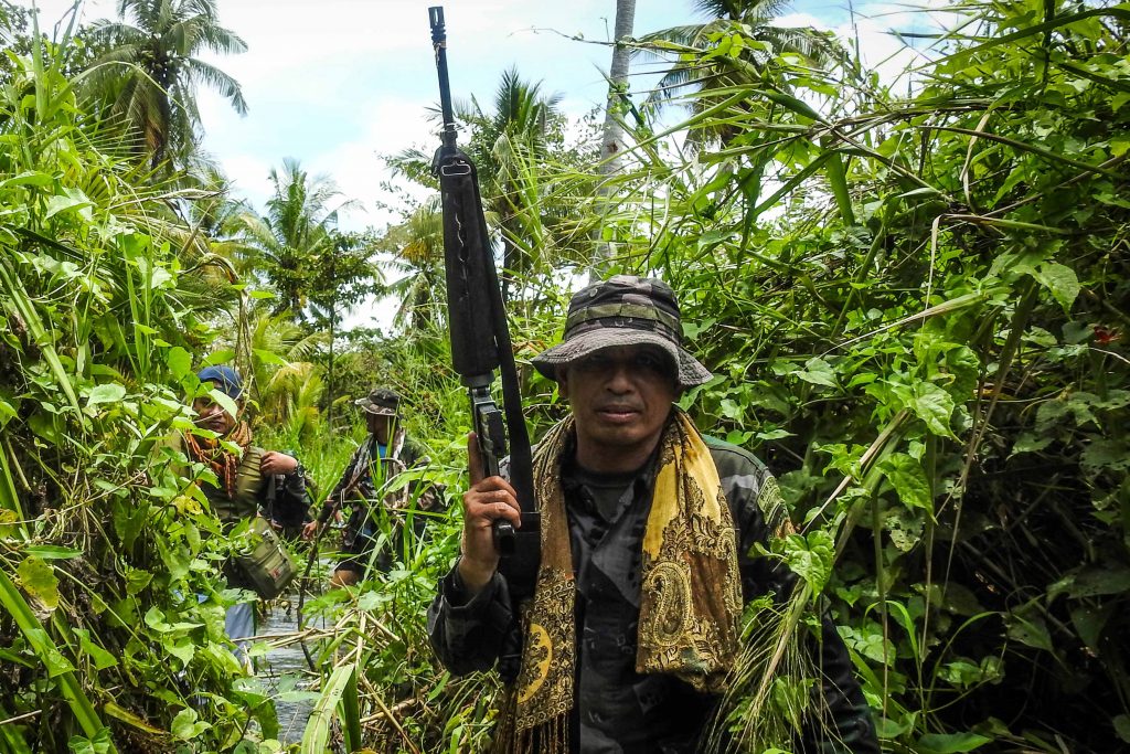 A government police officer along with members of the Moro Islamic Liberation Front (MILF-back) wading through a flooded farm on their way to the frontline in Datu Salibo town, Maguindanao province, in southern island of Mindanao. The Philippines' largest Muslim rebel group said on August 23 it had lost 10 fighters in battles to stop a "growing force" of radical militants who support the Islamic State group.