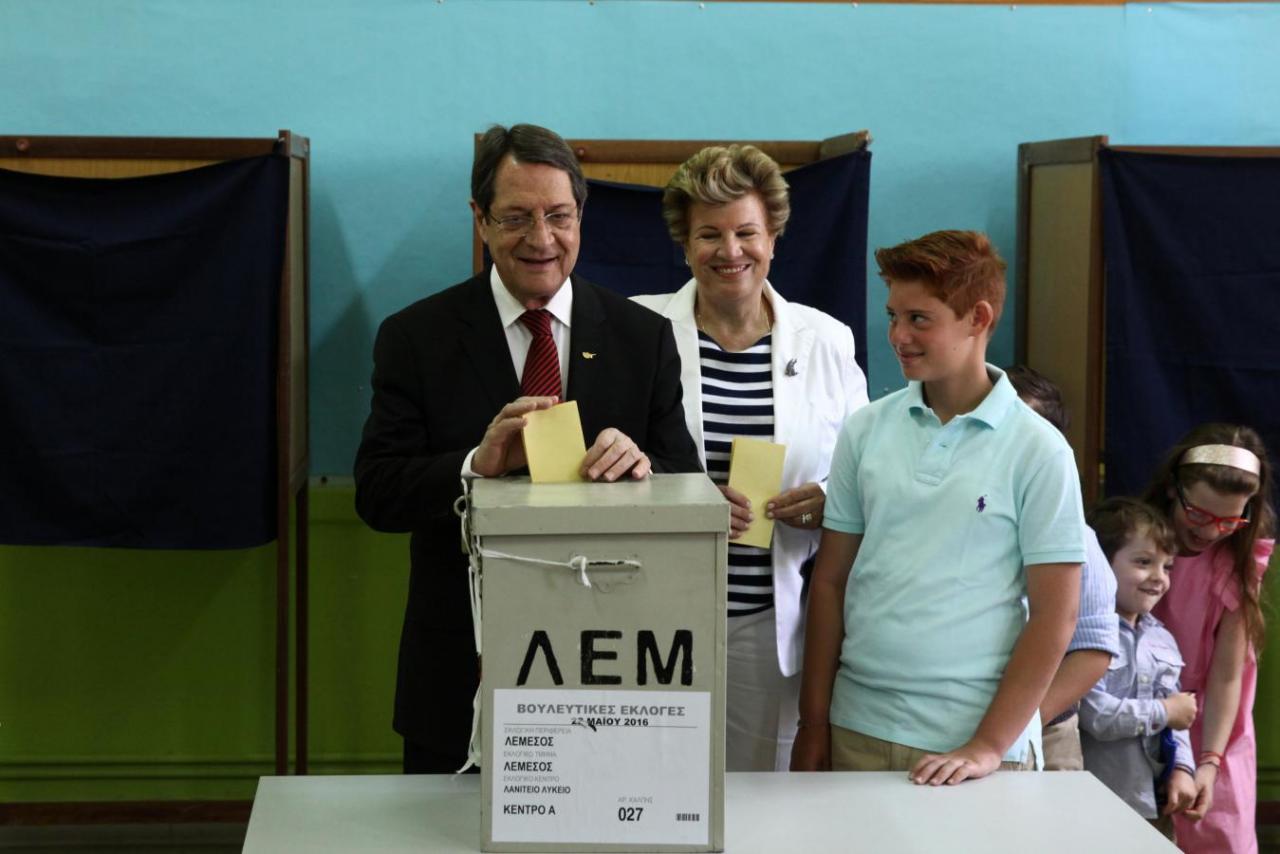 Cypriot President Nicos Anastasiades casts his vote at a polling station with his grandchildren and his wife Andri during parliamentary elections in Limassol