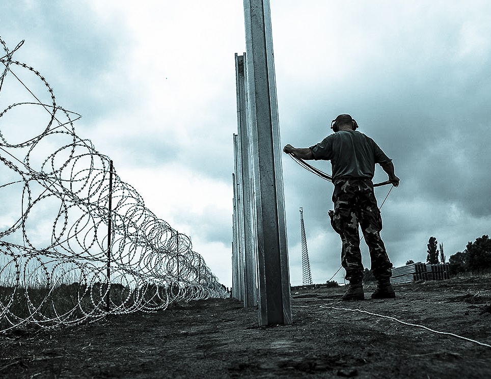 Members of the Hungarian Defence Force install barbed wire on the Hungarian-Serbian border to prevent illegal migrants from entering the country near Kelebia village in Hungary on August 17, 2015. / Hungary and Poland