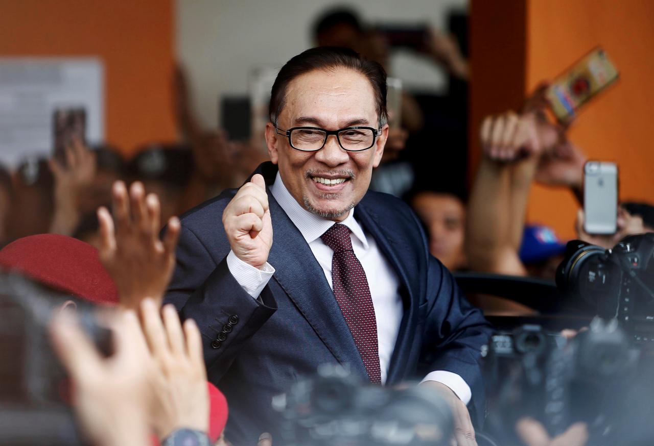 Malaysian politician Anwar Ibrahim gestures as he leaves a hospital where he is receiving treatment, ahead of an audience with Malaysia’s King, in Kuala Lumpur