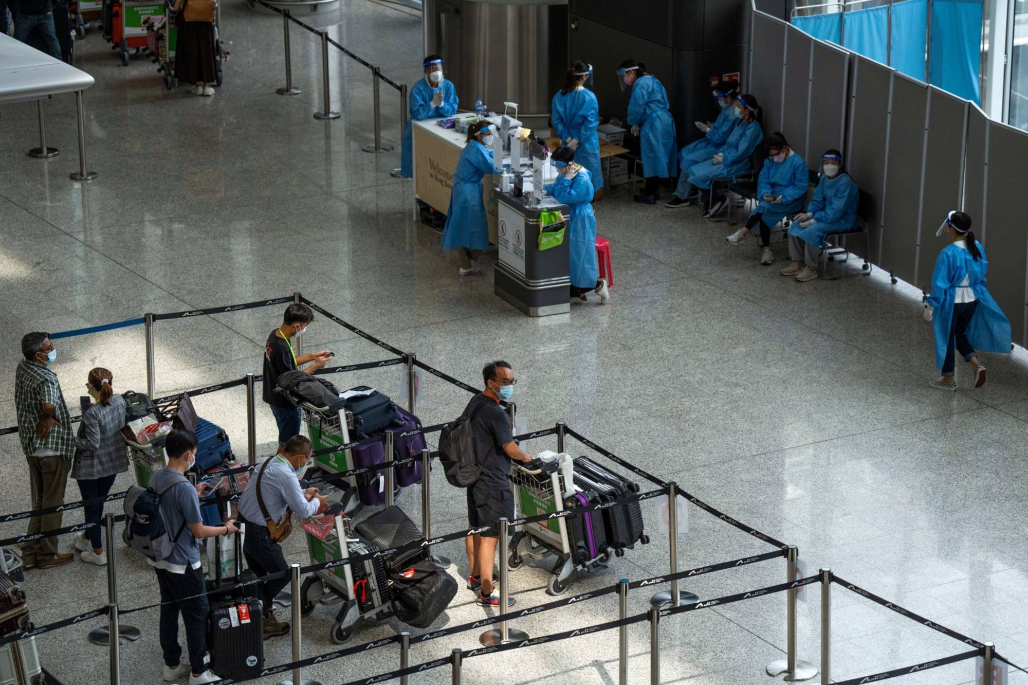 International arrivals to Hong Kong Airport wait to begin their quarantine