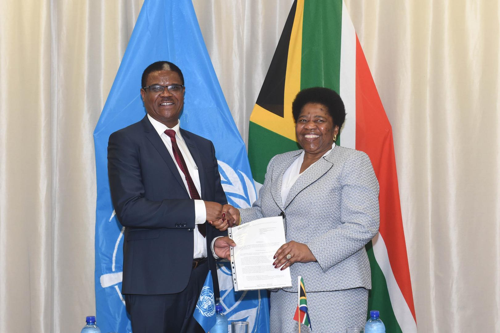 South African Deputy Foreign Minister Candith Mashego-Dlamini shaking hands with a WHO official.