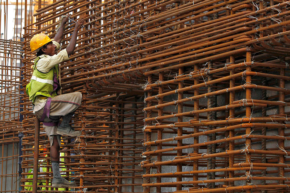An Indian worker scales scaffolding as the country’s economy rises