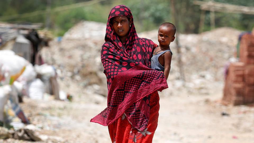 A woman from the Rohingya community walks through a camp in Delhi, India