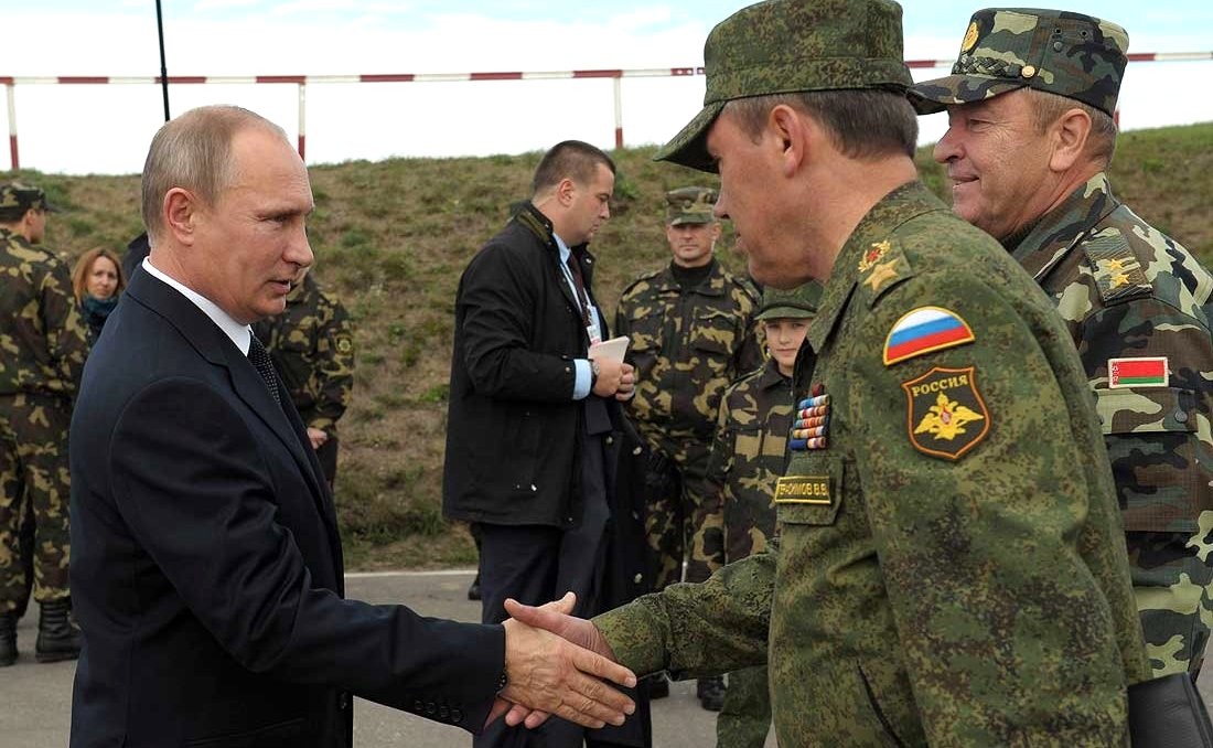 Vladimir Putin shakes the hand of a Russian and Belorussian soldiers engaged in Zapad exercises