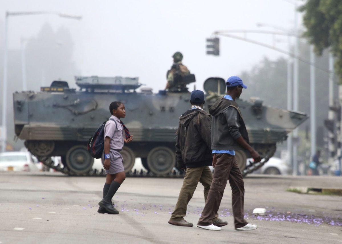 An armed soldier patrols a street in Harare, Zimbabwe. The army said Wednesday it has President Robert Mugabe and his wife in custody and is securing offices and patrolling the capital's streets following a night of unrest that included a military takeover of the state broadcaster.