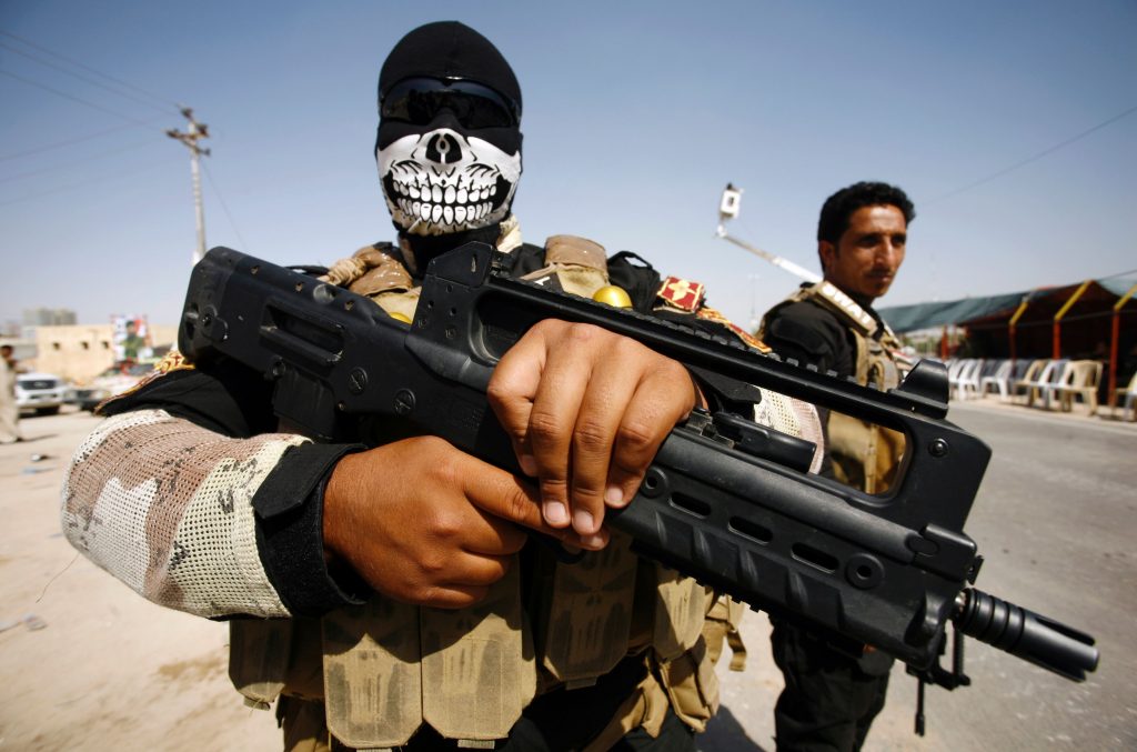 Members of the Popular Mobilisation Units supporting the government forces stand on the outskirts of the holy Iraqi city of Najaf on September 24, 2016, as take part in a military parade from Karbala to Najaf to review the military equipment to be used in the operation to re-take the city of Mosul from Islamic State (IS) group.