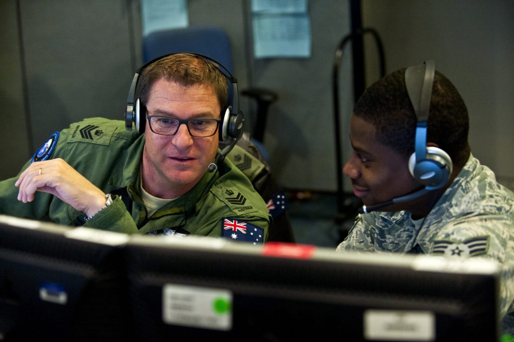 Royal Australian air force Flight Sgt. Sean Bedford (left) and U.S. Air Force Senior Airman Frederick analyze air missile defense systems inside the Combined Air and Space Operations Center-Nellis during Red Flag 14-1, on Feb. 5, 2014, at Nellis Air Force Base, Nev. Space duty technicians direct air missile ballistic warnings and provide communication to combat search and rescue teams. Beford is an Australian Space Operations Centre space duty technician and Frederick is a 603rd Air and Space Operations Center space duty technician.