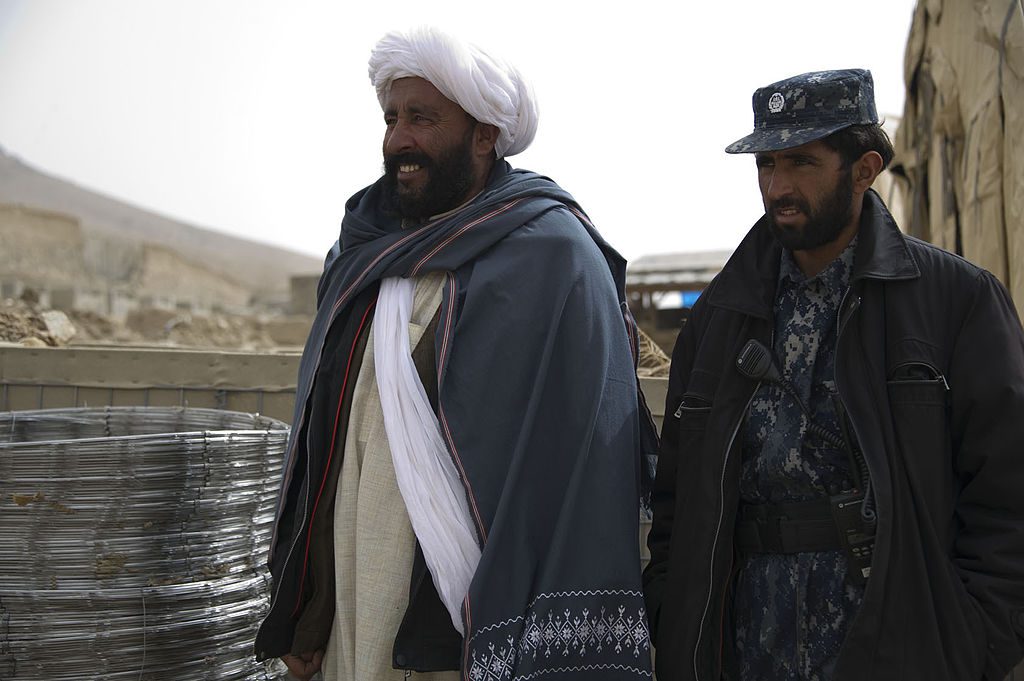 Abdul Samad, left, a recently reintegrated Taliban commander, and Afghan policeman Nic Mohammed, the commander of the Afghan Local Police in Khas Uruzgan, inventory supplies in Khas Uruzgan district, Uruzgan. 