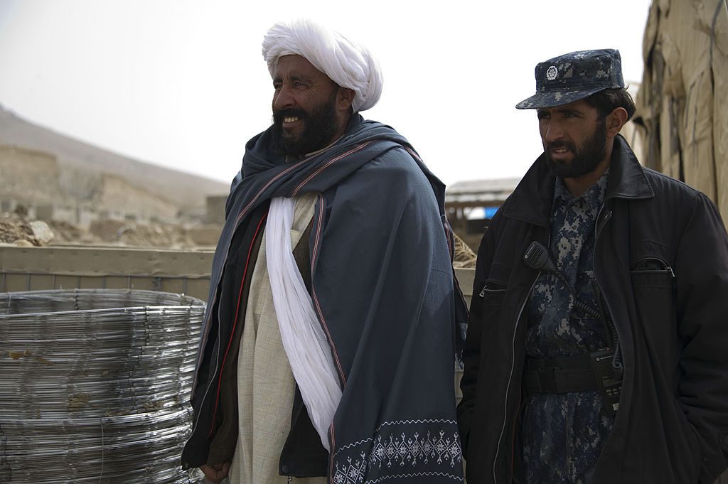 Abdul Samad, left, a recently reintegrated Taliban commander, and Afghan policeman Nic Mohammed, the commander of the Afghan Local Police in Khas Uruzgan, inventory supplies in Khas Uruzgan district, Uruzgan.
