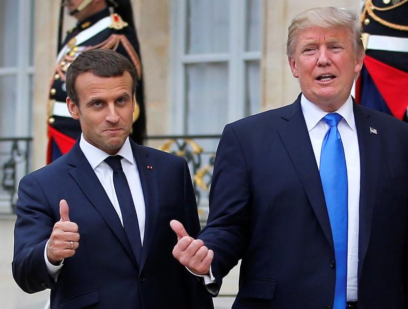 French President Emmanuel Macron and U.S. President Donald Trump react in the courtyard after a joint news conference at the Elysee Palace in Paris