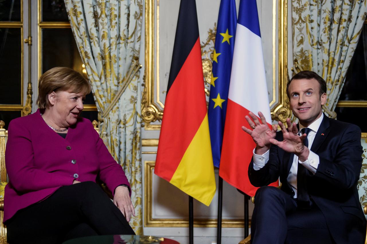 French President Emmanuel Macron and German Chancellor Angela Merkel react during their meeting at Elysee Palace in Paris