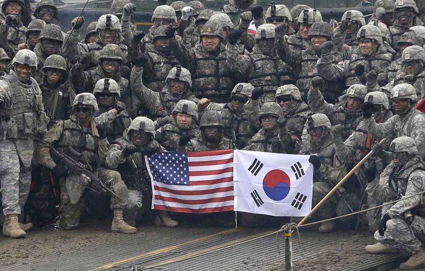 U.S. and South Korean army soldiers pose on a floating bridge on the Hantan River during a joint military exercise against a possible attack from North Korea, in Yeoncheon, South Korea, in December 2015. / Trump-Kim