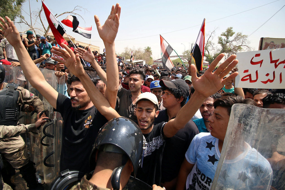 People shout slogans during a protest near the main provincial government building in Basra