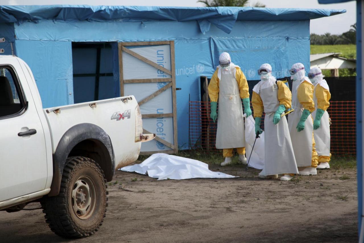 Health workers, wearing head-to-toe protective gear, prepare for work, outside an isolation unit in Foya District, Lofa County in this handout photo