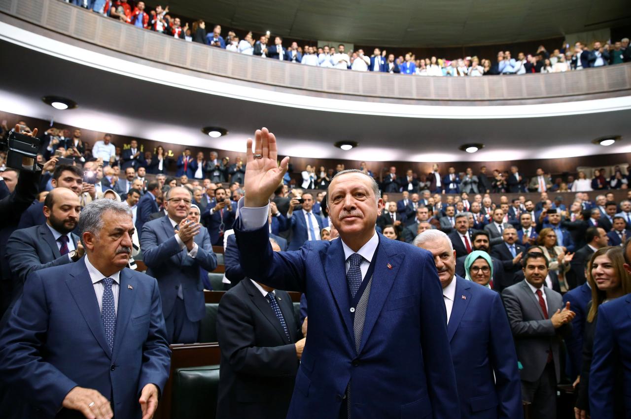 Turkish President Tayyip Erdogan greets members of parliament from his ruling AK Party as he arrives a meeting at the Turkish parliament in Ankara