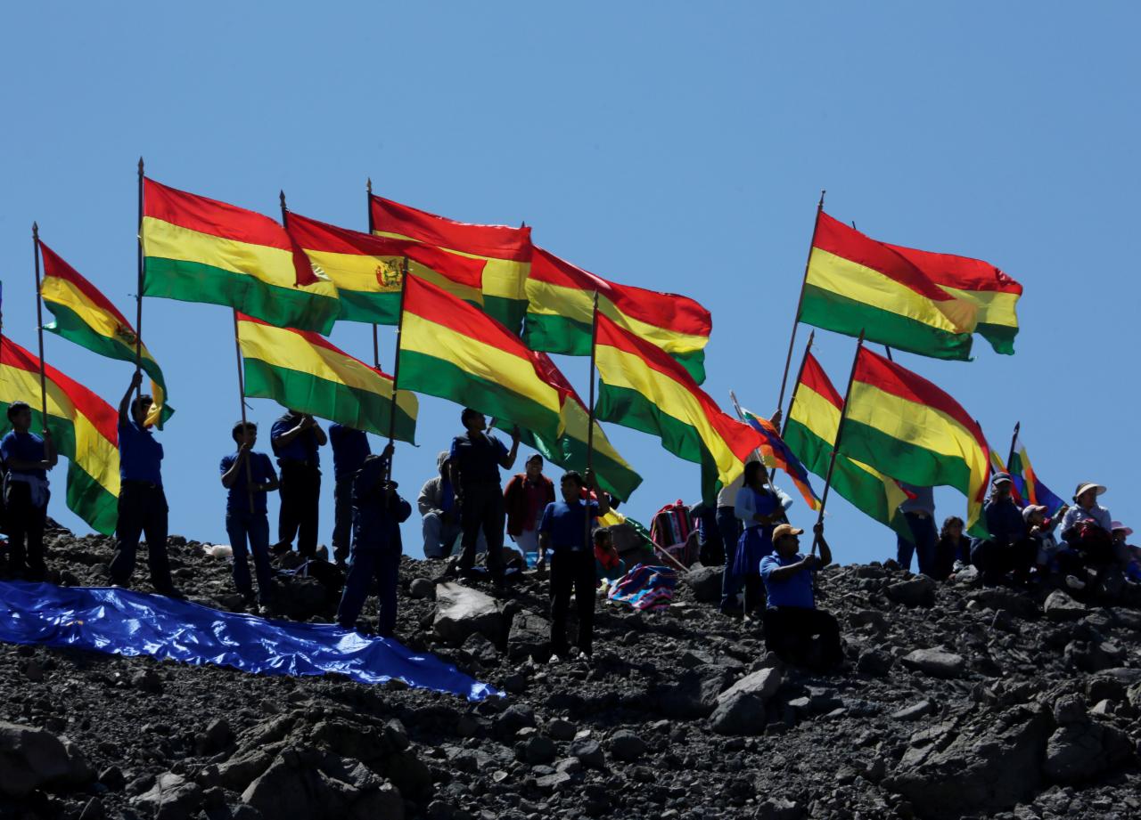 FILE PHOTO: Bolivians hold national flags as they attend to watch the theatricalization of the battle of Canchas Blancas