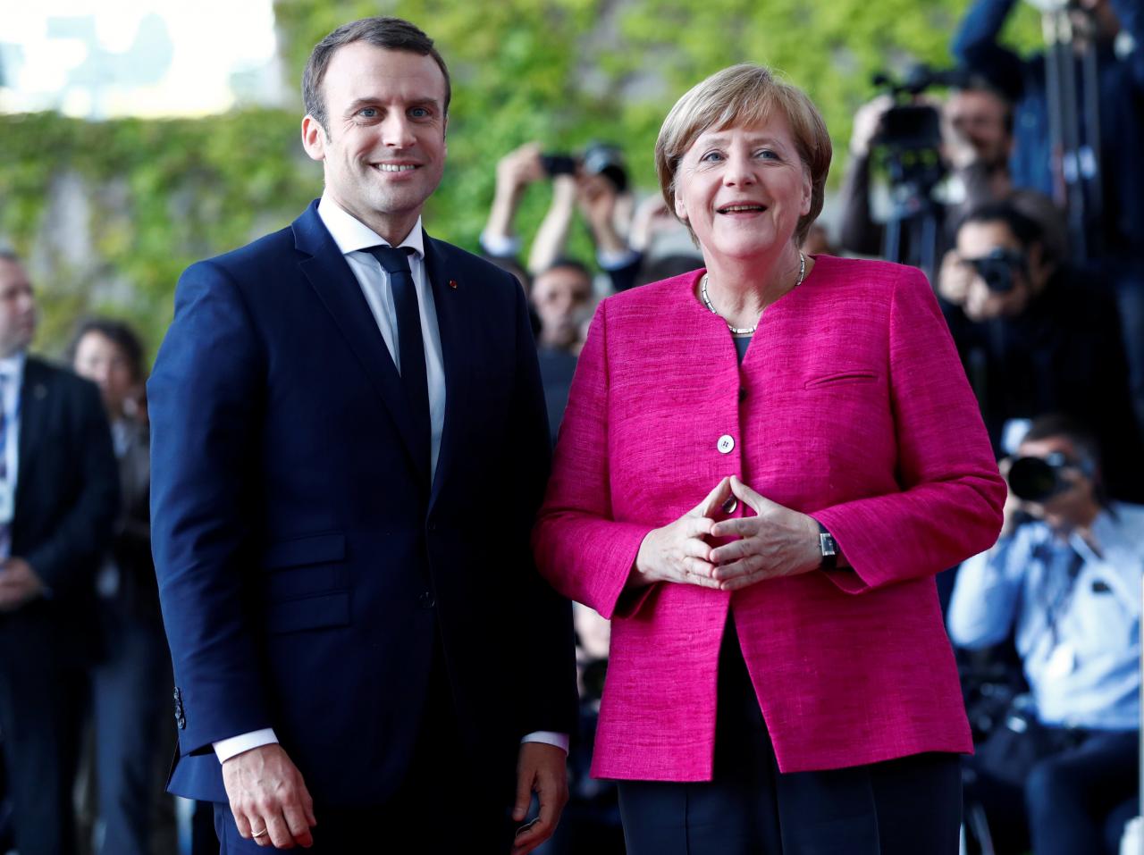 German Chancellor Angela Merkel and French President Emmanuel Macron arrive at a ceremony at the Chancellery in Berlin