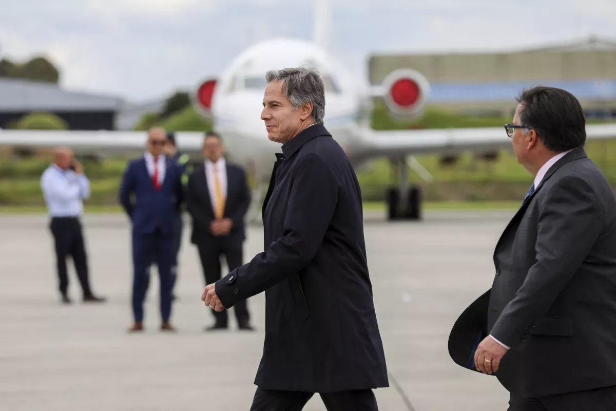 U.S. Secretary of State Antony Blinken walking across a tarmac in front of a plane at the start of his Latin American tour